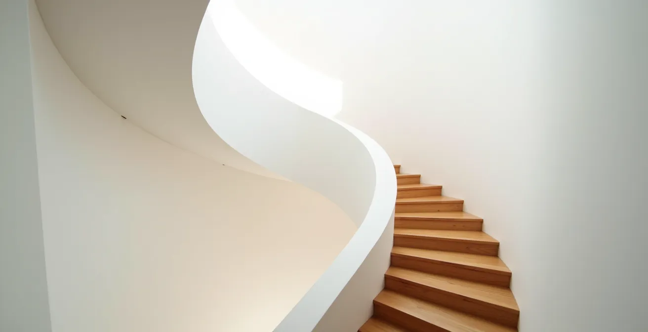 Vue en plongée d'un escalier en colimaçon étroit montrant la difficulté d'installation